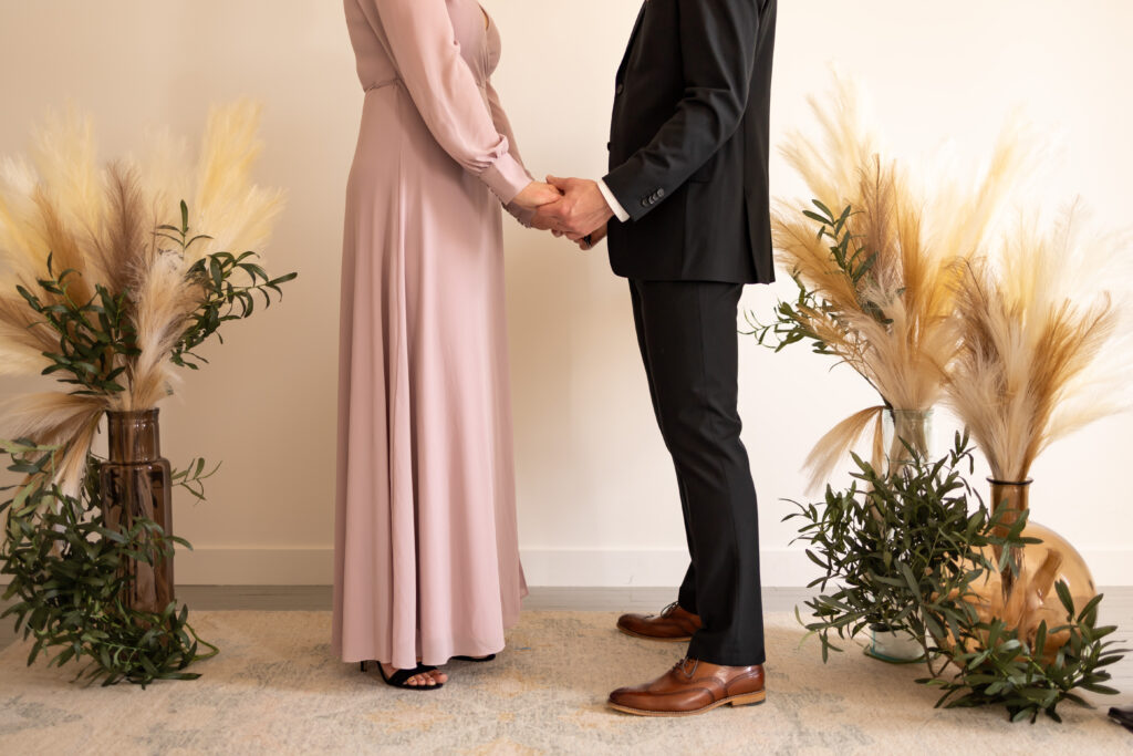 Couple stands at the altar facing each other and holding hands